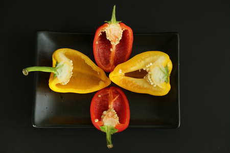 Yellow red bell peppers black background