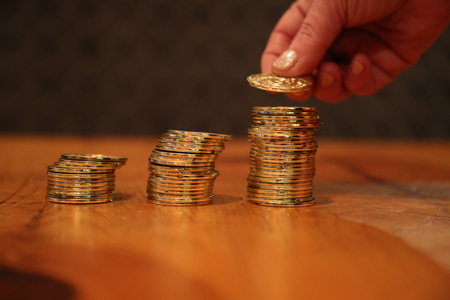 Closeup coins stacks hand putting coin top