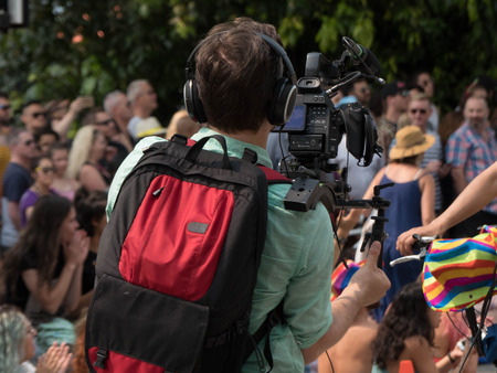 Video camera operator shooting outdoor camera man workingのeditorial素材