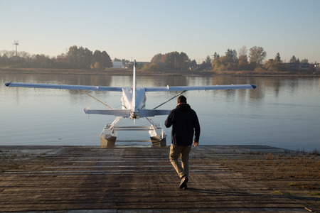 Young man aviator  walk dock water plane aviation の写真素材