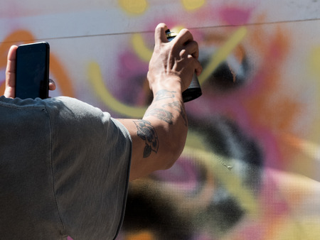 Young male hand tatto using paint spray background