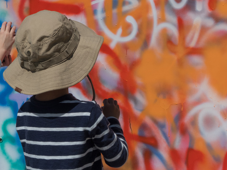 Young artist painting graffiti wall bright colours backgroundの写真素材
