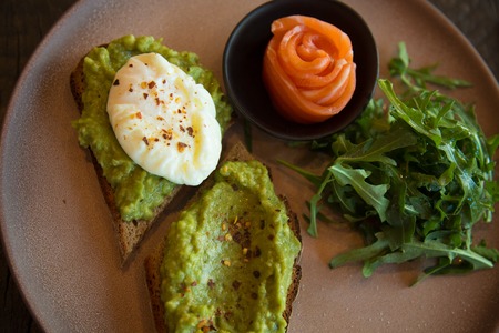 Gourmet appetizers salmon avocado spread toasts arugula plate top view