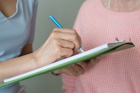 Female hand writing closeup woman filling up formの写真素材