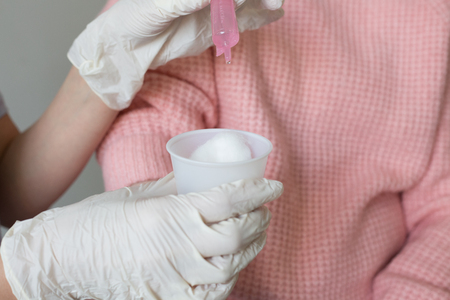 Close up hands medical gloves cotton balls containerの写真素材