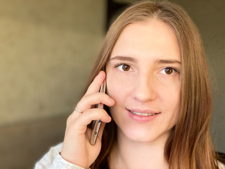 Smiling young female talking cellphone home copy space