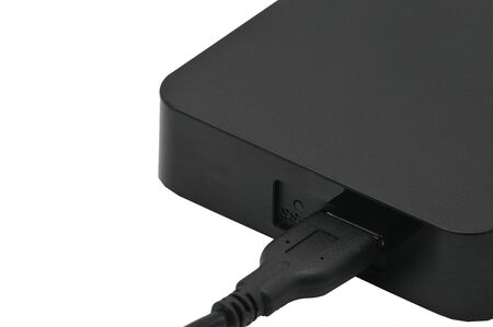 Portable hard drive for backing up various files on an isolated white background