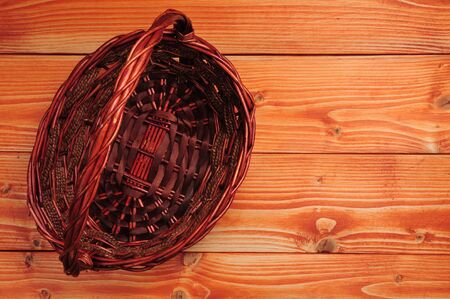 Knitted straw basket on wooden backgroundの写真素材