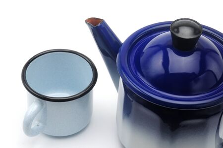Vintage teapot in blue with a mug on an isolated white backgroundの写真素材