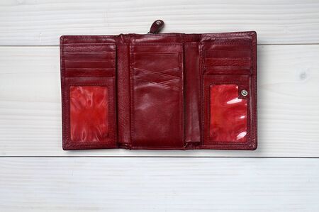 Brown leather purse on a white wooden background