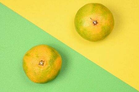 Ripe tangerines on a yellow-green backgroundの写真素材