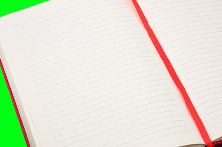 Red notebook on an isolated green backgroundの写真素材