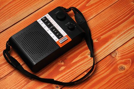 Vintage radio for listening to radio programs on a wooden background