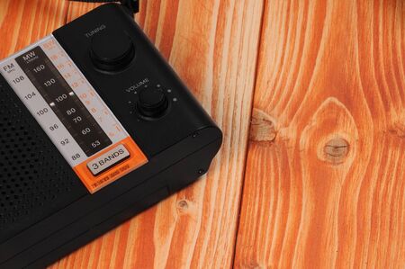 Vintage radio for listening to radio programs on a wooden background