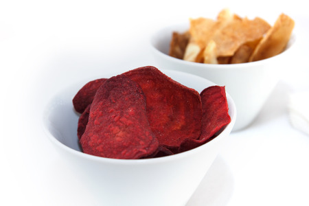Two bowls of fried root vegetable chips.の写真素材