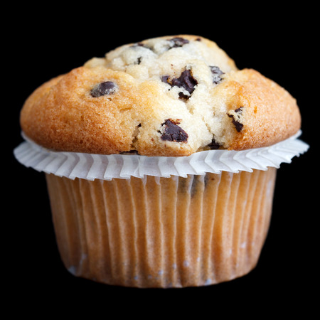Light chocolate chip muffin in wax liner on black.の写真素材