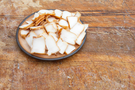 Pieces of smoked lard on ceramic plate. Place for text.の写真素材
