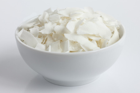Coconut flakes in white ceramic bowl. In perspective.の写真素材