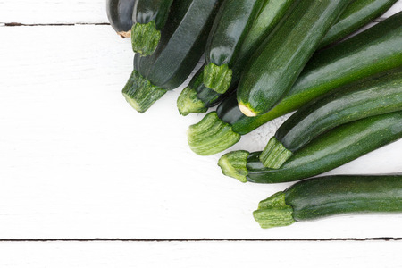 Pile of whole courgettes from above on white weathered wood.の写真素材