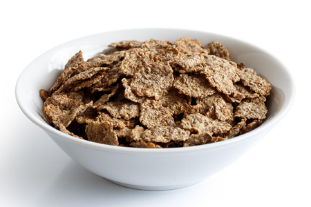 Wheat bran breakfast cereal with no milk in a bowl isolated on white background.の写真素材