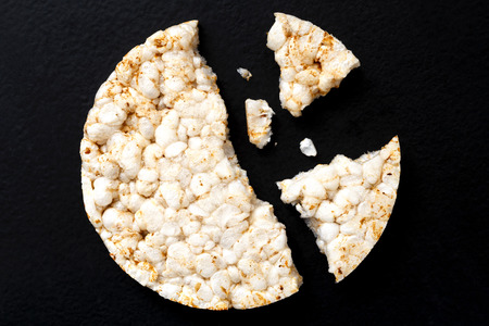 Broken puffed rice cake from above isolated on dark.の写真素材