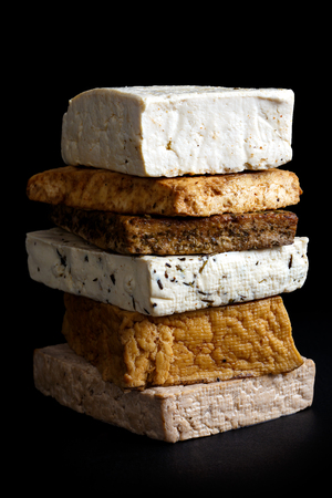 Stack of mixed tofu blocks isolated on black.の写真素材