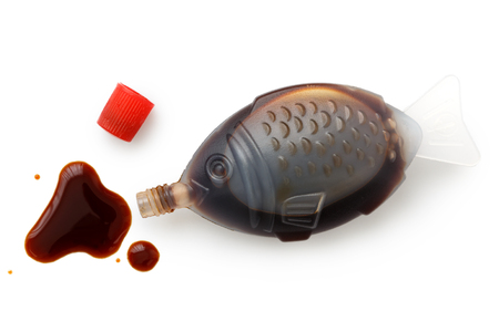 Open fish shaped take away soya sauce isolated on white from above. Spilled sauce.の写真素材