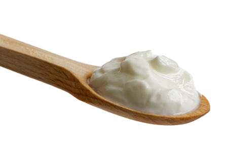 Skyr yoghurt on wooden spoon isolated on white.の写真素材