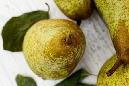 Closeup of abate fetel pear with leaves on white painted wood from above.の写真素材