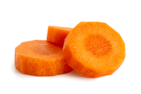 Three round slices of peeled carrot isolated on white.の写真素材