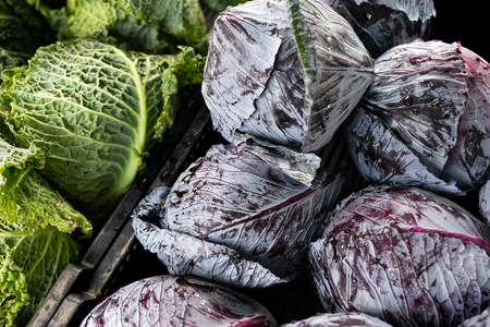 Whole red and curly cabbages at market from above. Background.の写真素材