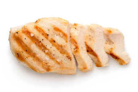 Partially sliced grilled chicken breast with grill marks, ground black pepper and salt isolated on white. Top view.の写真素材