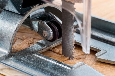 An electrical jigsaw cutting through chip board. Blurred background.の写真素材