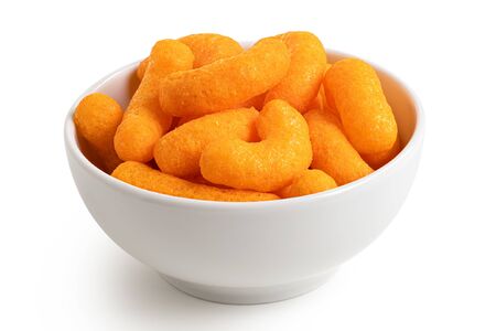 Extruded cheese puffs in a white ceramic bowl isolated on white.の写真素材