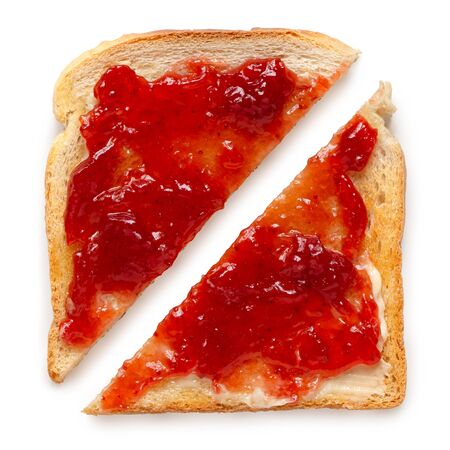 Two triangles of white toast spread with butter and strawberry jam isolated on white. Top view.の写真素材