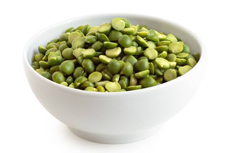 Dried green split peas in a white ceramic bowl isolated on white. High angle.の写真素材