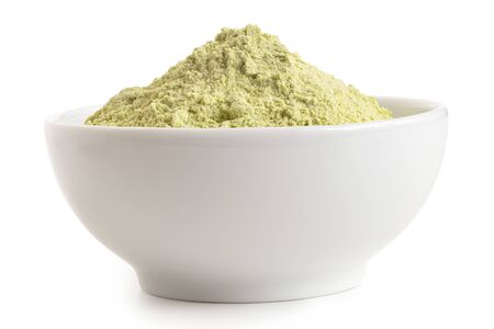Dried green pea flour in a white ceramic bowl isolated on white. Low angle.の写真素材