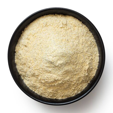 Dried lentil flour in a black ceramic bowl isolated on white. Top view.の写真素材