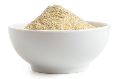 Dried lentil flour in a white ceramic bowl isolated on white. Low angle.の写真素材
