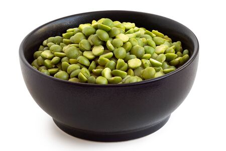 Dried green split peas in a black ceramic bowl isolated on white. High angle.の写真素材