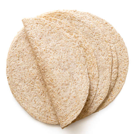 Folded tortilla on top of a stack of plain spelt and oat tortilla wraps isolated on white. Top view.