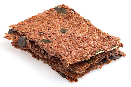 Stack of linseed and pumpkin raw crackers isolated on white.の写真素材