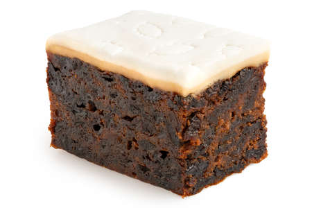 Piece of iced fruit cake isolated on white.の写真素材