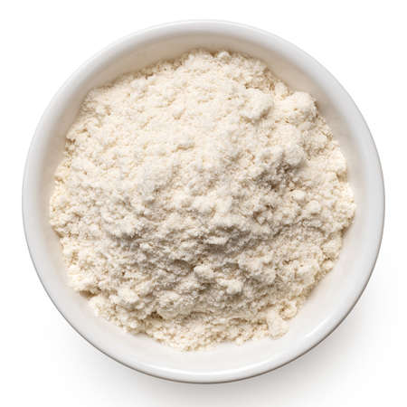 Brown rice flour in a white ceramic bowl isolated on white. Top view.の写真素材