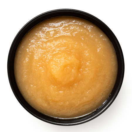 Apple sauce in a black ceramic bowl isolated on white. Top view.の写真素材