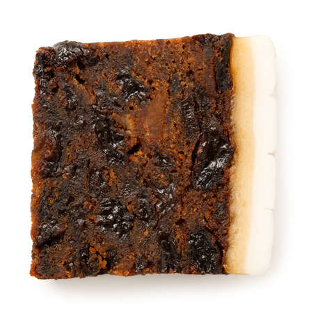 Slice of iced fruit cake isolated on white. Top view.の写真素材