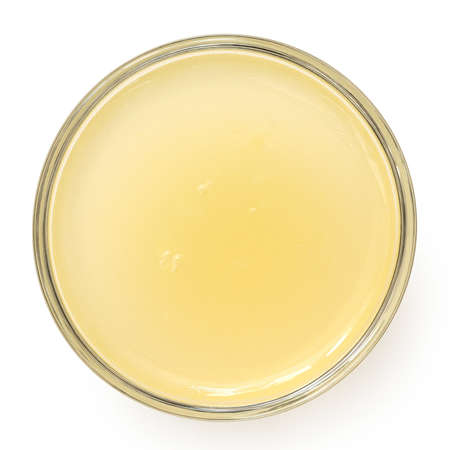 Freshly squeezed lemon juice in a glass bowl isolated on white. Top view.の写真素材