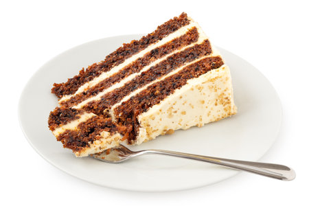 Slice of carrot cake with cream cheese filling and frosting on white plate with mouthful of cake on fork isolated on white.の写真素材