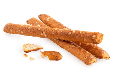 Three salted pretzel sticks with crumbs isolated on white.