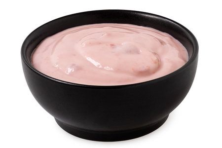 Strawberry yogurt in a black ceramic bowl isolated on white.の写真素材